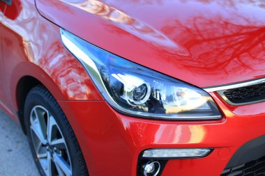 Güzel kırmızı araba yolda duruyor.