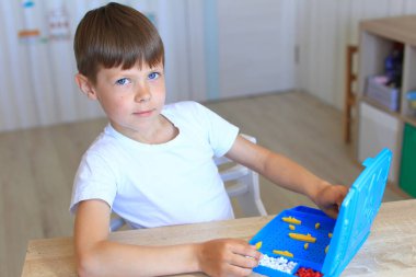 Evde bir çocuk masa oyunu oynuyor.