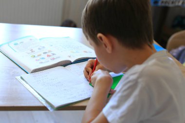 Bir çocuk izolasyon üzerine ödev yapıyor. Ev ödevi.