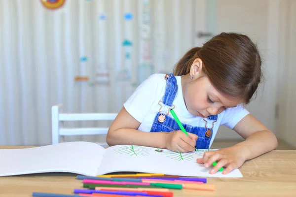 Çocuk ev yalıtımında renkli kalemlerle kağıda resim çiziyor..
