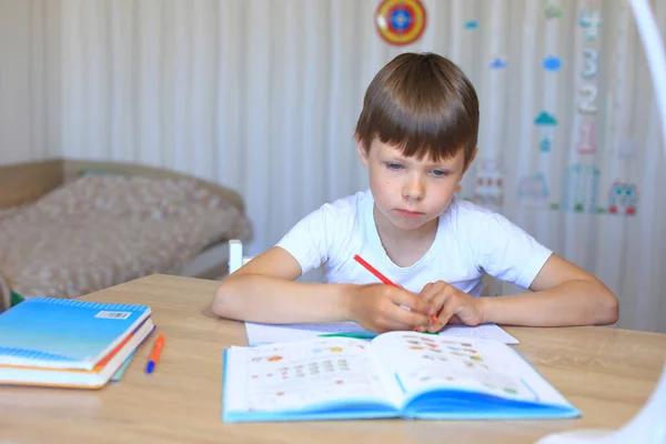 Een kind maakt huiswerk over isolatie. Huiswerk. — Stockfoto