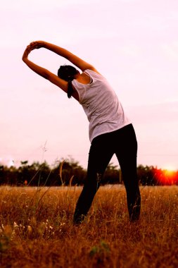 Parktaki genç bir kadın. Kollarını uzatıyor. .