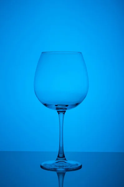 Пустой бокал вина на голубом фоне — стоковое фото