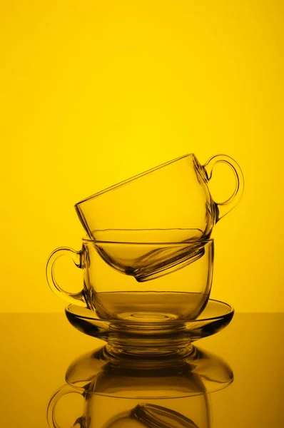 Two transparent glass cups yellow background Stock Photo