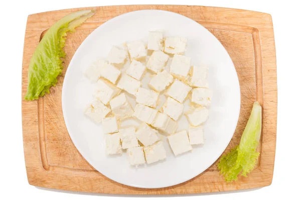 Verduras sobre fondo blanco. Queso feta, verduras, tabla de cortar, plato sobre un fondo blanco — Foto de Stock