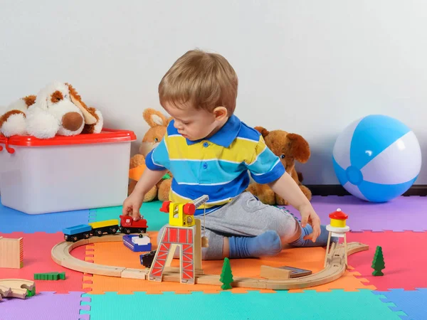 Kleines Kind spielt mit Holzeisenbahn. — Stockfoto