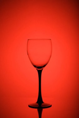 Kırmızı arka planda şarap kadehi