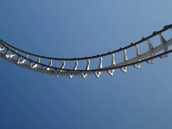 Carris de montanha-russa no parque de diversões. Rails estão apenas pendurados no céu no fundo do céu azul — Fotografia de Stock