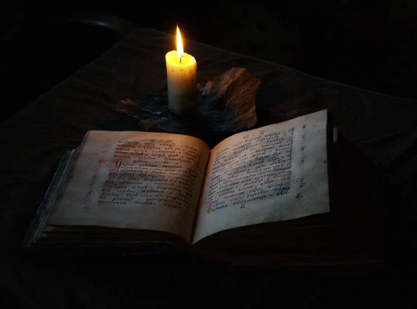 Винтажные книги, открытые для чтения при помощи древней лампы — стоковое фото