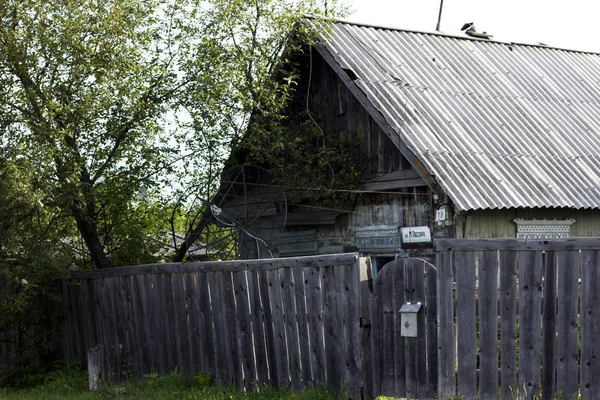 Granja de pueblo casa de madera y cerca de madera y árbol. Pobre casa de gente pobre. Casa étnica de pueblo — Foto de Stock