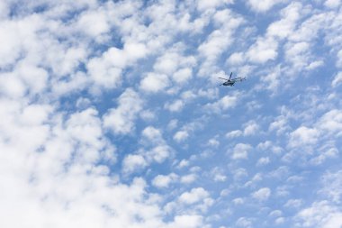 Beyaz mavi gökyüzü bulutlar arasında üzerinde helikopter