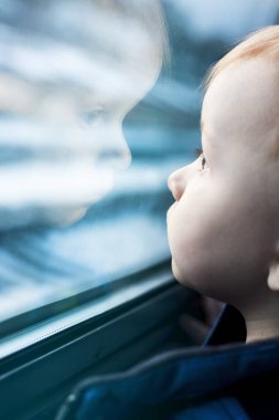 Yansıma penceresinde bakarak yürümeye başlayan çocuk.