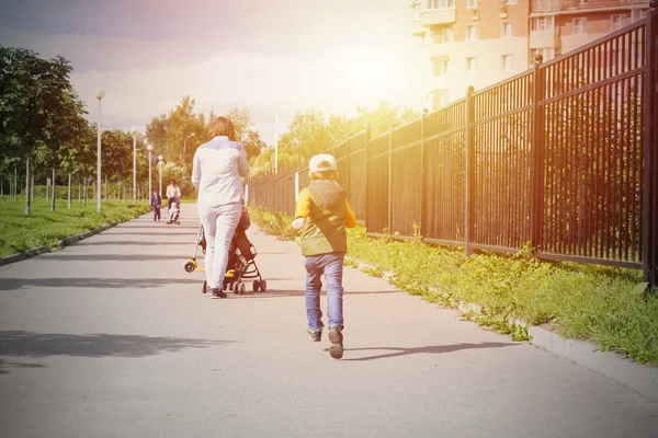 Anne bebek arabası ile yürüyüş ile açık çalışan çocuk.