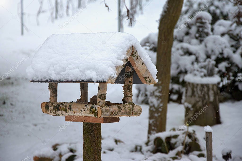 Bird feeder in winter covered with snow. Home made. Helping birds in winter.