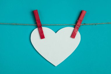 Beyaz kağıt kalp kırmızı iğneler iple bağlı