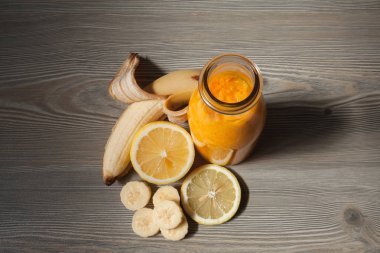 Taze turuncu smoothie muz ve bir şişe limon ile.  