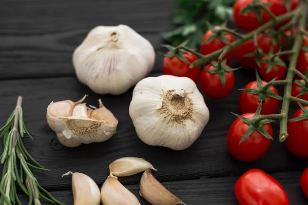 Sarımsak ve domates siyah Ahşap mutfak masasında. Yakın çekim