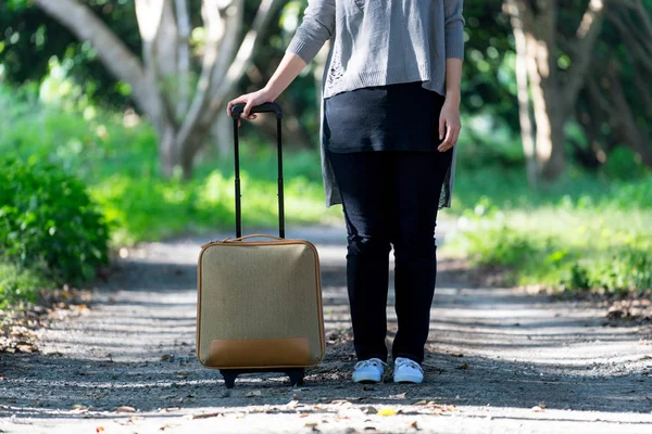 森にスーツケースを持って旅行者. — ストック写真
