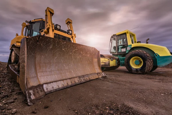 Bouw van een zandweg in Spanje met behulp van een graafmachine en een wals — Stockfoto