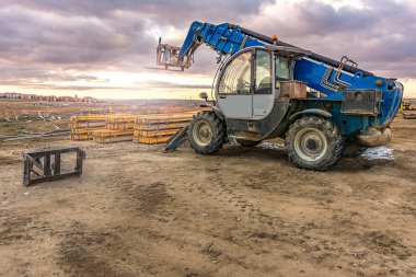 İnşaat alanında forklift, inşaat parçalarını kaldırmaya hazırlanıyor.