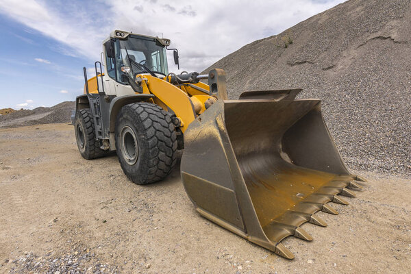 Mountain of gravel and excavator for transport