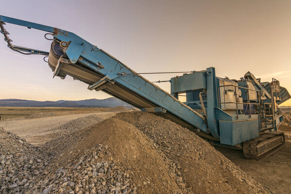 Stone crusher machine in a quarry or open-pit mine, to transform into gravel