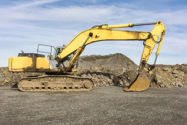 Ein großer gelber Bagger bewegt Stein in einem Steinbruch — Stockfoto