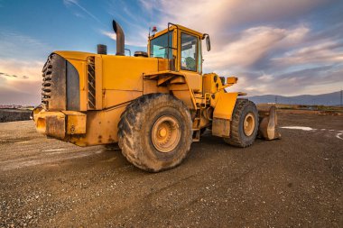 Bir inşaat sahasında çalışma gününün sonunda kazıcı