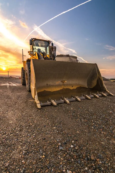 Excavadora al final de una jornada de trabajo en una obra de construcción — Foto de Stock