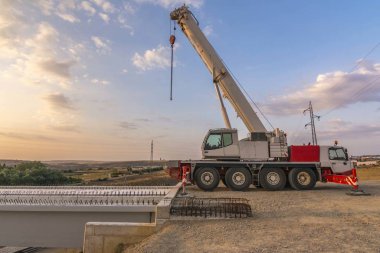 Crane trucks in the construction of a bridge clipart