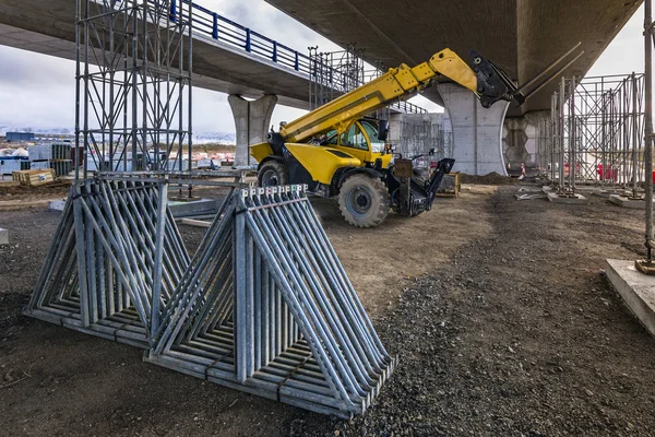 İnşaat alanında forklift, inşaat parçalarını kaldırmaya hazırlanıyor.