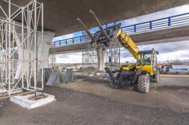 İnşaat alanında forklift, inşaat parçalarını kaldırmaya hazırlanıyor.