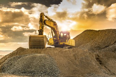 Yol inşaatındaki kazıcı çalışıyor. İnşaat için gerekli makineler