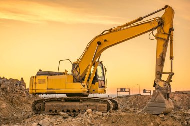 Yol inşaatındaki kazıcı çalışıyor. İnşaat için gerekli makineler
