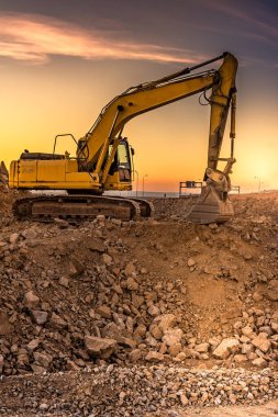 Yol inşaatındaki kazıcı çalışıyor. İnşaat için gerekli makineler