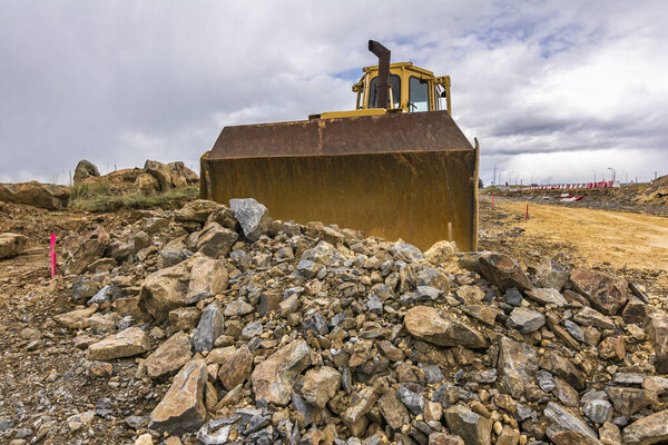 Excavator transporting rock and stone at the construction site of a road