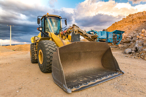 Excavator and stone crusher in a quarry