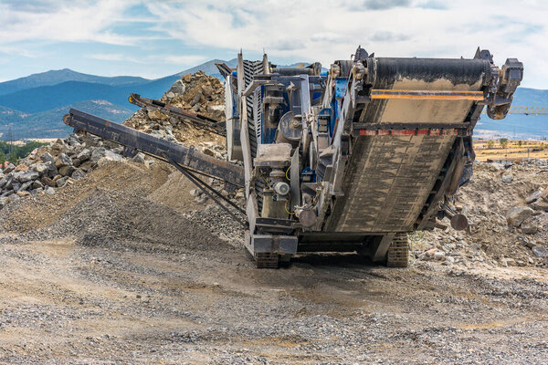 Heavy and mobile machinery in a quarry to transform stone into construction material