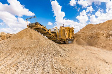 Taş ocağındaki ağır ve seyyar makineler taşları inşaat malzemesine dönüştürüyor.