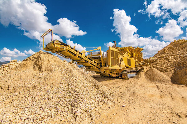 Heavy and mobile machinery in a quarry to transform stone into construction material