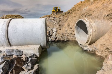 Bir yol inşaatında araziyi düzleştirmek ve düzleştirmek için kazıcı