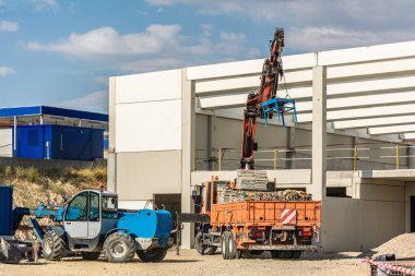 Yapı için malzeme boşaltan kamyonu olan bir gemi yapımı.