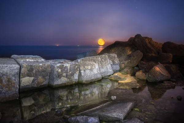 Vista nocturna de la orilla del mar con una enorme luna llena —  Fotos de Stock