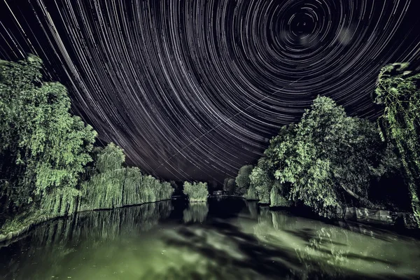 Night photo with star circles on the pond.