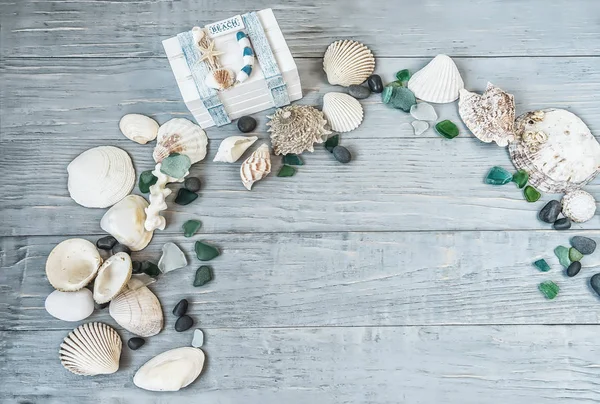 Sea, beach saver, background, postcard. the mood of rest, vacation. Shells of stone pebbles and a white chest on a gentle light blue vintage, gray, old, wooden background.