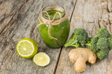 Smoothies yeşil sebze ve çevresinde çeşitli yeşil sebzeler üzerinde eski bir ahşap arka plan kırık. Vitaminler vücut detoks temizlik, kokteyl.