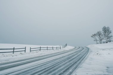 Karla kaplı Kış manzarası. Yol, kar yağışı gidiyor. Minimalizm.