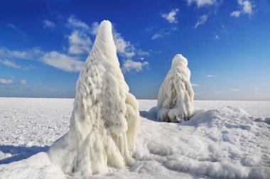 Büyük buz buz sarkıtları iskele ve donmuş denizin oluşumu. Parlak güneşli.