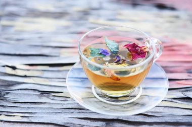 İlginç bir şekilde kırık bir eski yüzeyi çiçek çay ile şeffaf bir fincan.