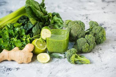 Smoothies yeşil sebze ve çevresinde çeşitli yeşil sebze ışık gri arka plan üzerinde. Vitaminler vücut detoks temizlik, kokteyl.